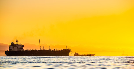 oil tankers ship at sea on a background of sunset sky. oil tankers in the ocean. early in the mornin