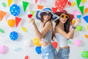 celebration new year or birthday party group of asian young woman and confetti happy,funny concept.drinking wine happy and fun in new year celebrate, color balloon  background.