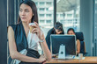 © Mongkolchon - female office woman take abreak from working by standing beside window with having coffee