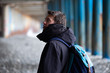 © ILIA - Young man stands under the old metal bridge on the beach
