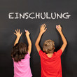 girl and boy writing on a blackboard, german text Einschulung, in english school enrollment