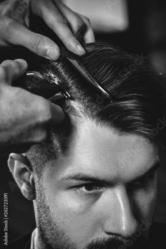 Young Handsome Barber Making Haircut For Attractive Bearded Man At