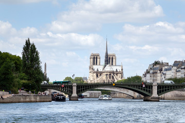 River Seine, bridge, boat and Cathedral Notre Dame de Paris (eastern facade with a spire on the roof) in Paris (France, Europe)