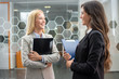 © Bojan - Two smiling business women arguing and communicating in the office