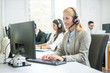 © Bojan - Smiling young customer support woman with headset using computer while talking with client in call center