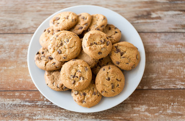 Wall Mural - food, junk-food and eating concept - close up of oatmeal cookies with chocolate chips on plate