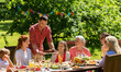 © Syda Productions - leisure, holidays and people concept - happy family having festive dinner or summer garden party