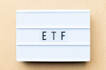 Poster - White lightbox with word ETF (abbreviation of Exchange Traded Fund) on wood background