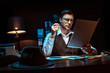 © LIGHTFIELD STUDIOS - Concentrated detective in glasses reading dossier in dark office