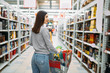 Woman with cart in alcohol drinks department