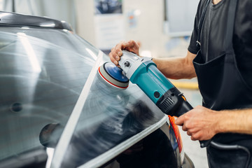 Worker removes the track from wiper blade on car