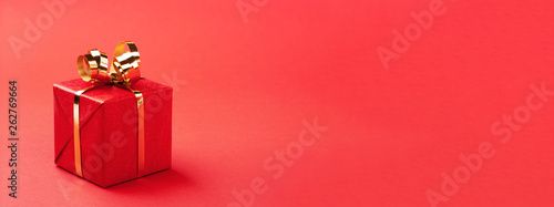Red gift box on red background.
