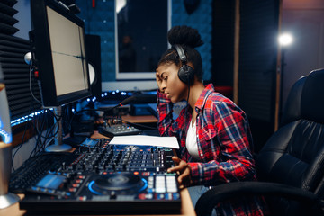 Wall Mural - Female sound operator in audio recording studio