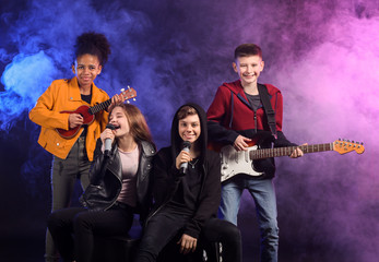 Wall Mural - Band of teenage musicians on dark background