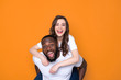 © Yakobchuk Olena - Happy interracial couple in white T-shirts posing for camera in studio