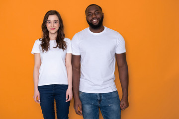 beautiful interracial couple in white t-shirts posing for camera