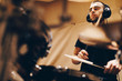 © David Gail/ADDICTIVE STOCK - Positive handsome male with headphones playing on drums in studio