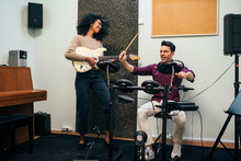 Cheerful Man Playing Guitar And Woman Playing Drums