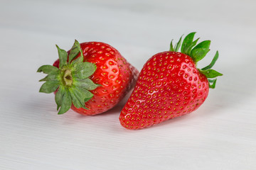 Two strawberries on white wood 