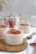 Healthy vegan dairy free dessert - tapioca pearls pudding with coconut milk and strawberry chia jam close up, served in glass jar