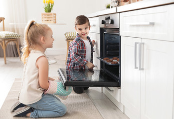 Wall Mural - Little kids baking cookies in oven at home