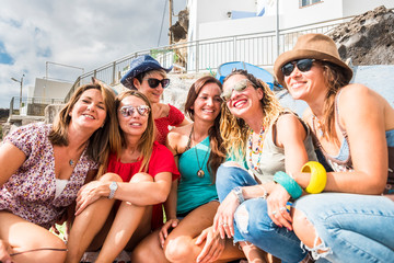 Wall Mural - Group of cheerful and happy young women friends enjoy the day during summer vacation together in friendship - people have fun and laugh - beautiful ladies in a sunny day