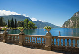 Fototapeta  - Uferpromenade Riva del Garda, mit antikem Geländer und Blumendekoration, Gardasee Ufer