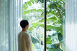 © ChaoShu Li/Stocksy - Cute Asian women standing in front of a picturesque window