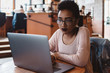 © Chelsea Victoria/Stocksy - A young woman using her laptop in a cafe