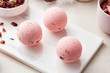 © 365mm/Stocksy - Three bath bombs with rose petals.
