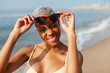 © Bonninstudio/Stocksy - Portrait of woman with sunglasses on beach