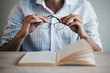 © Cindy Prins/Stocksy - Hands holding glasses before reading a book