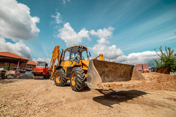 Yellow bulldozer excavator on the construction site warehouse working machine