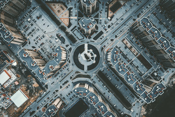 Wall Mural - Top down aerial view of round road intersection with cars and new modern buildings, drone shot