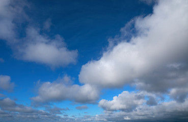 blue sky with white and grey clouds to horizon