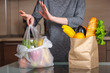 © Artem - Woman chooses a paper bag with food and refuses to use plastic. Environmental protection and the abandonment of plastic