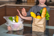 © Artem - Woman chooses a paper bag with food and refuses to use plastic. Concept of environmental protection
