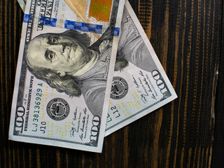 Two hundred dollars bills on a wooden background. new hundred dollar bill. Close up american dollar banknotes