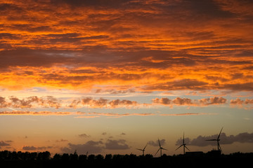 Sticker - Windturbines in the dutch landscape below a dramatic colorful sky at sunset