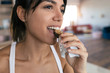 © nenetus - Sporty young woman eating muesli snack at home.