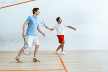Full Length View Of Two Sportsmen Playing Squash In Four-walled Court