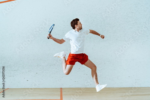Dekoracja na wymiar  sportowiec-w-koszulce-polo-skaczacy-podczas-gry-w-squasha-na-korcie-o-czterech-scianach