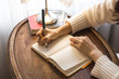 © bong - Woman writing on notebook or diary with brown desk