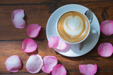 Fototapeta Tulipany - coffee latte decorate with pink rose on wood table background. background and textures - Image