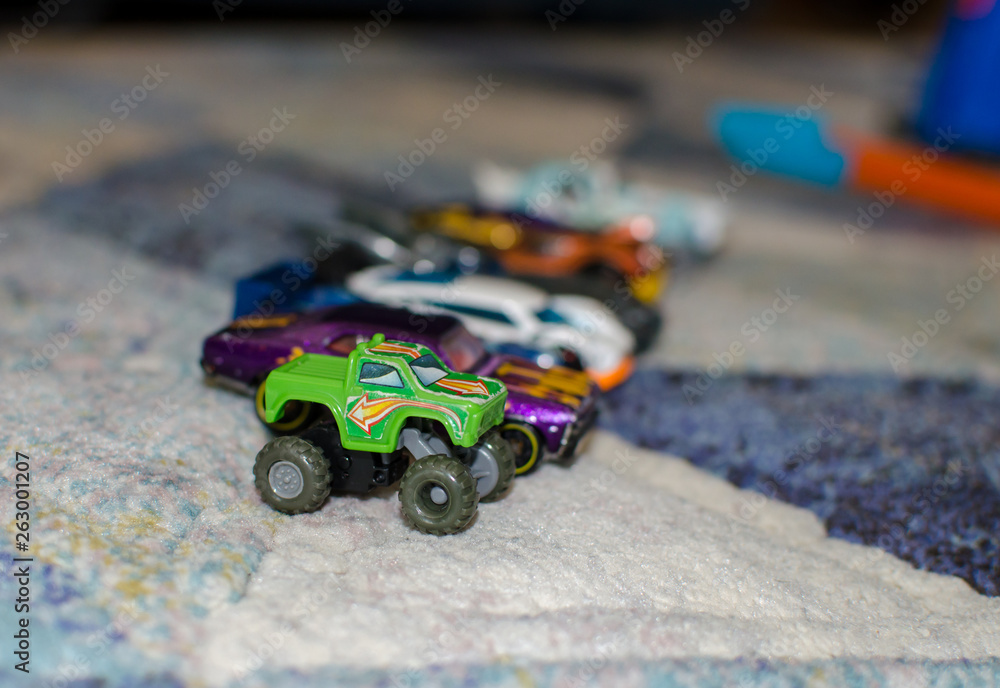 Toy cars are lined up on the carpet. Stereotypical alignment of ...