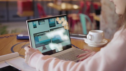 Wall Mural - Side view of unrecognizable freelance female website designer creating application design for different devices on laptop while having coffee at table in cafe (ATTN templates designed by ME)