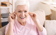 © Prostock-studio - Cheerful senior lady wearing headphones, listening to music