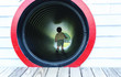 © Tierney - Toddler boy playing in a tunnel at a playground