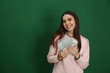 © New Africa - Young woman with money on color background