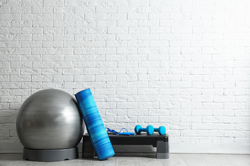 set of fitness inventory on floor near brick wall. space for text
